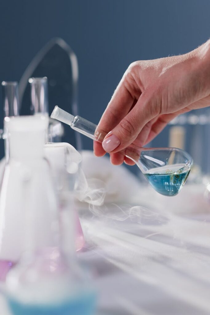pexels-photo-10187629 Close-up of a hand holding a flask in a laboratory setting with smoke effect.