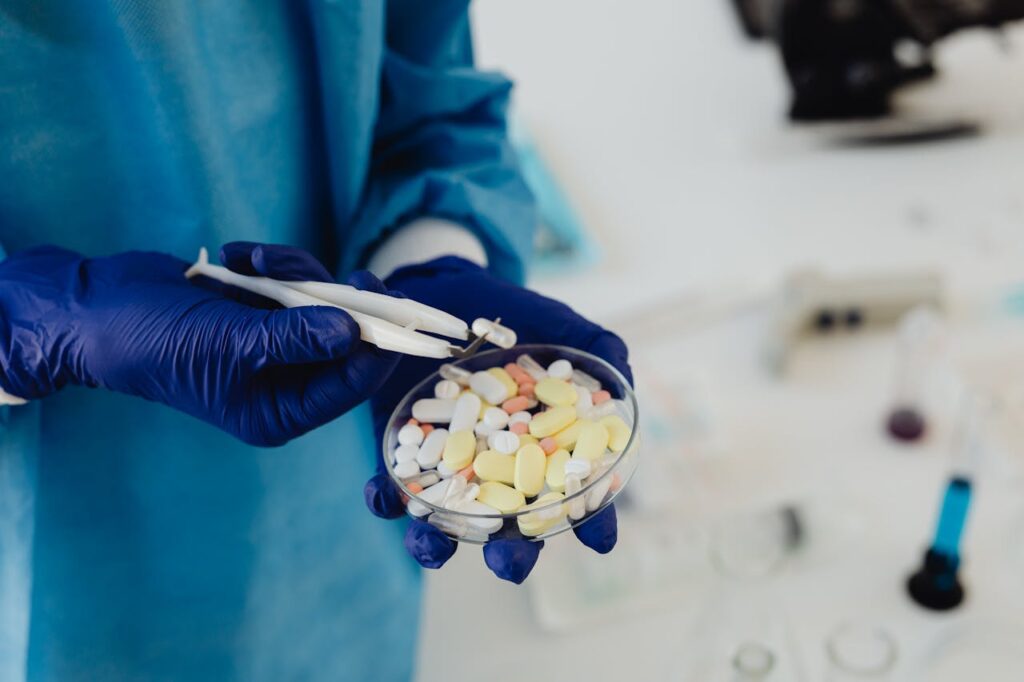 pexels-photo-8539078 Scientist in gloves using tweezers to handle assorted pills in a petri dish.